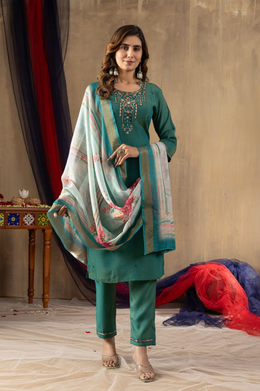 Woman in teal traditional outfit with a multicolored dupatta against a neutral background
