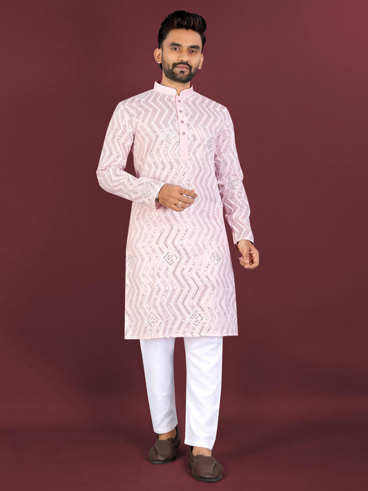 Man wearing a pink kurta with white pants on a maroon background